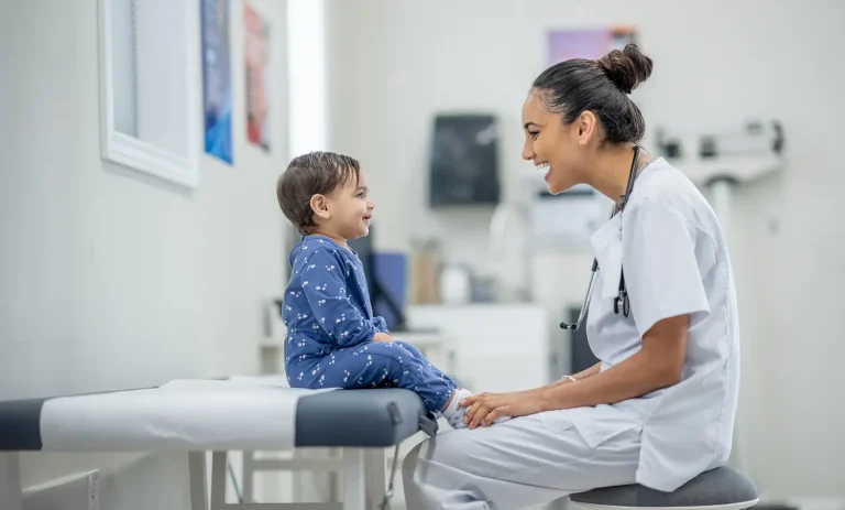 pediatric nurse laughing with toddler