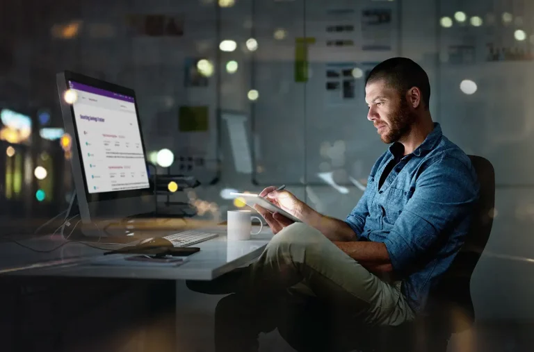 hombre de negocios utilizando un ordenador y una tableta digital durante una noche en la oficina