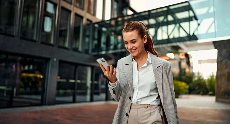 happy beautiful business woman in formal clothes holding a phone and smiling