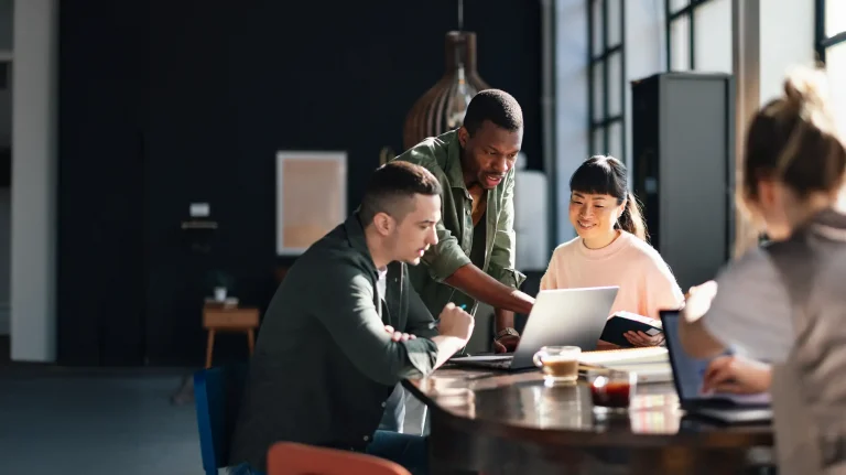 Young professionals collaborating in a bright co-working space, showcasing teamwork and productivity.