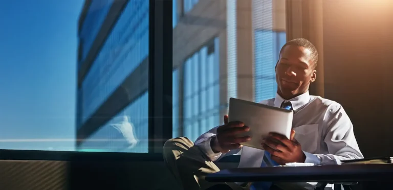 business man sitting at desk in sun filled office