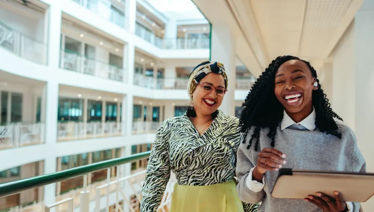 oworkers walking through an office building while laughing and enjoying each other's company.