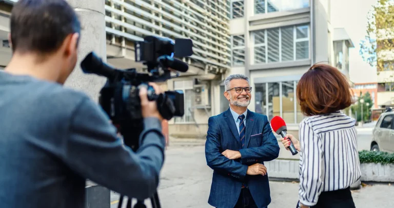 A female journalist with a microphone interviewing a businessman